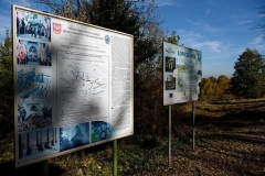 Tablice informacyjne na tle zarośli i błękitnego nieba