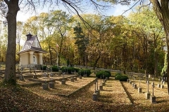 Mogiły żołnierskie, po lewej kaplica cmentarna, w tle las