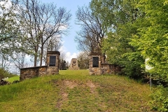 Kawałek muru z wejściem na terem cmentarza wojennego