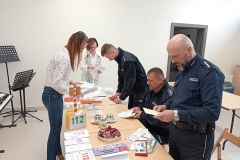 Komisja konkursowa ogląda prace plastyczne rozłożone na stoliku