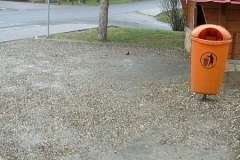 Pomarańczowy kosz na śmieci obok przystanku