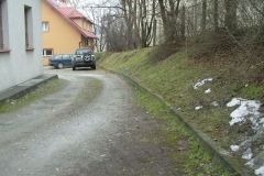Utwardzony wjazd na parking za urzędem, z prawej strony nasyp porośnięty trawą