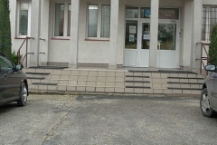 Schodki i wejście do Urzędu Gminy, przed wejściem kolumny betonowe