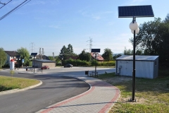 Chodnik z kostki brukowej, w dali plac w centrum Świebodzina, po lewej latarnia z panelem fotowoltaicznym