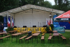 Biały namiot sceniczny, przed nim stoliki i ławki