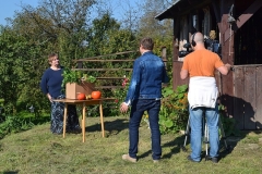 Kamerzysta filmuje kobietę stojącą obok stolika z warzywami