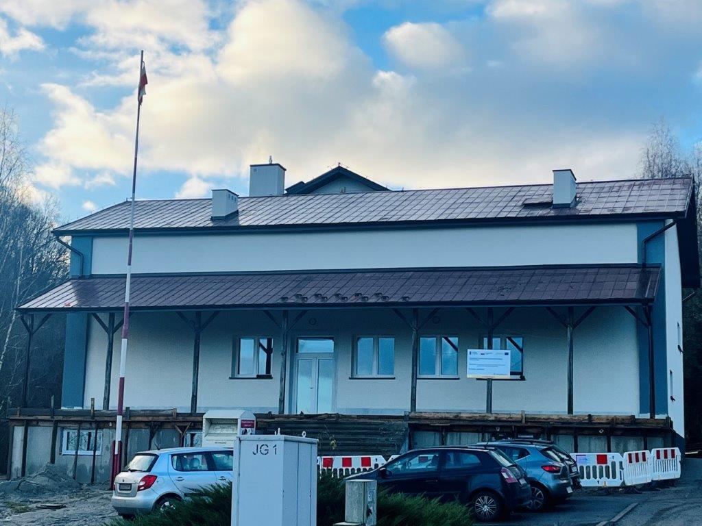 Budynek Publicznej Szkoły Podstawowej w Rychwałdzie po termomodernizacji, przed budynkiem zaparkowane samochody
