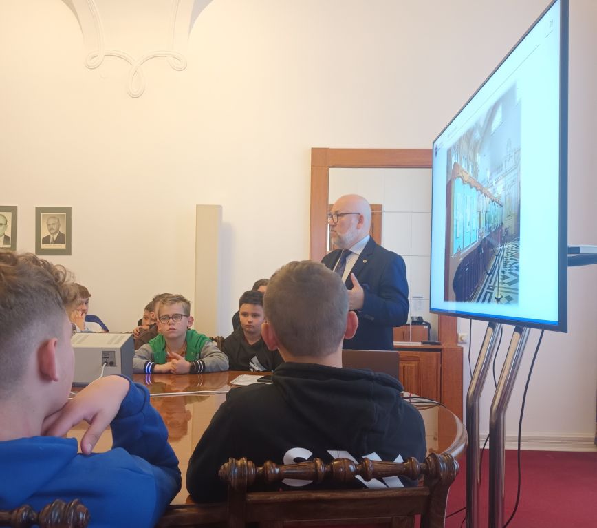 Uczniowie słuchają opisu do prezentacji wyświetlonej na tablicy multimedialnej