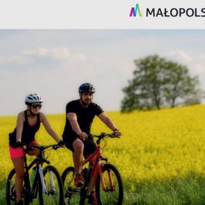 Mężczyzna i kobieta jadą na rowerach górskich na tle łąki