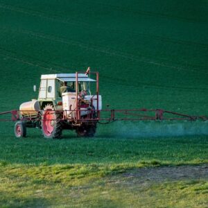 Traktor z opryskiwaczem na zielonym polu