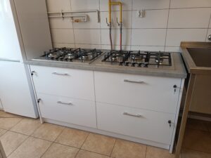 Dwie płyty gazowe z szafkami ustawione w pomieszczeniu kuchennym.