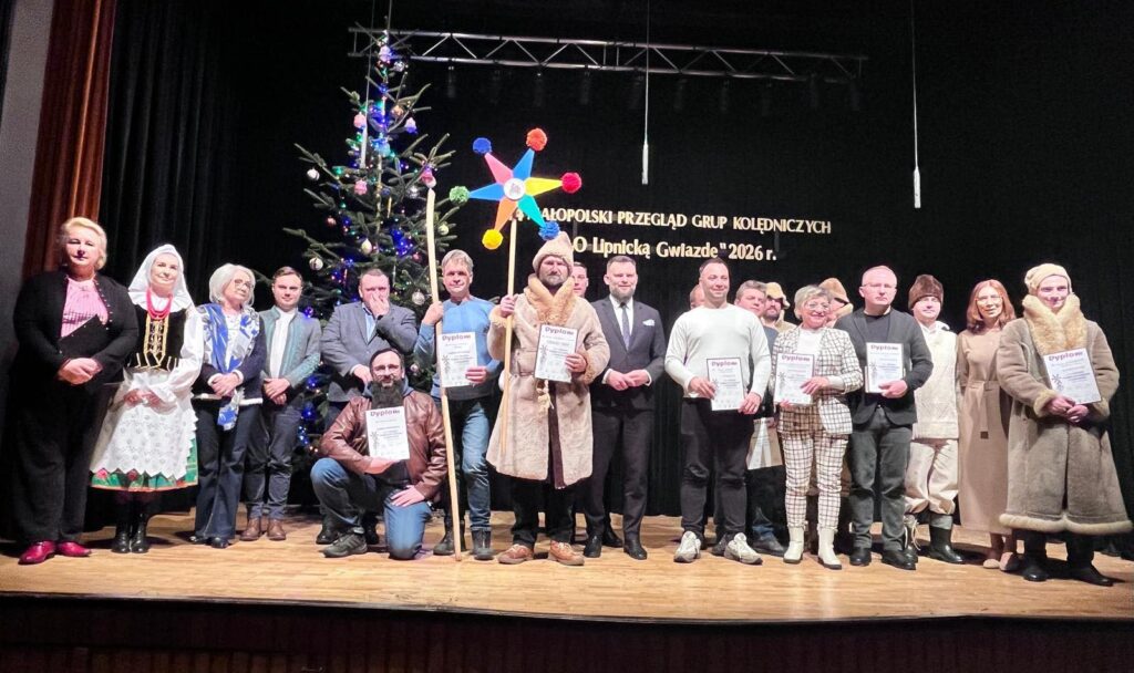 Kolędnicy pozują do zdjęcia na scenie