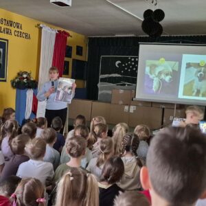 Pani z Towarzystwa Opieki nad Zwierzętami z oddziału w Skrzyszowie opowiada uczniom szkoły podstawowej o działalności organizacji
