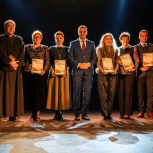 Wójt Gminy stoi na scenie wraz z osobami, które otrzymały medale