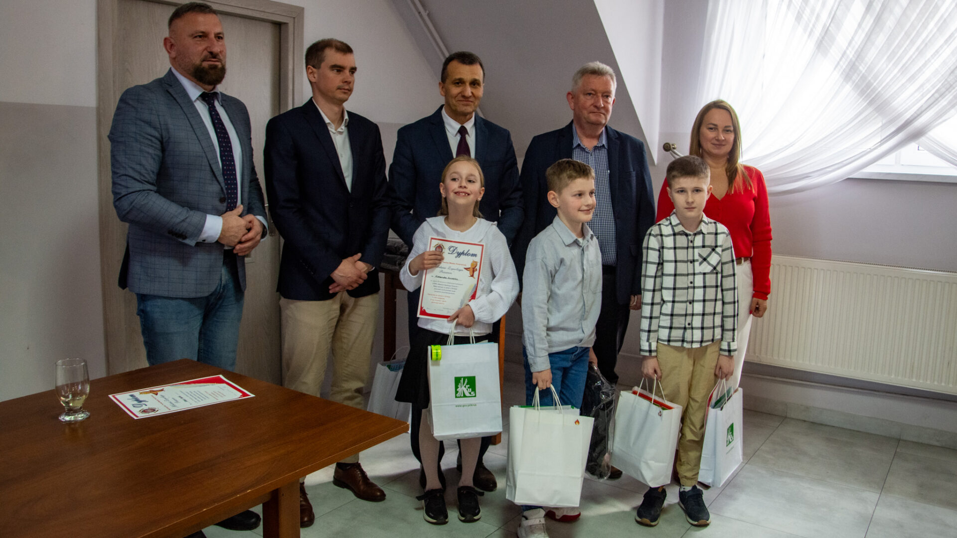 Troje dzieci i pięcioro dorosłych pozuje do zdjęcia grupowego.