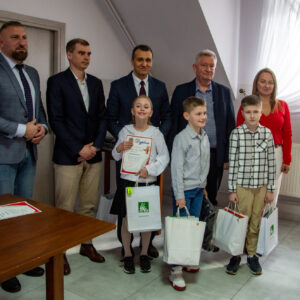 Troje dzieci i pięcioro dorosłych pozuje do zdjęcia grupowego.