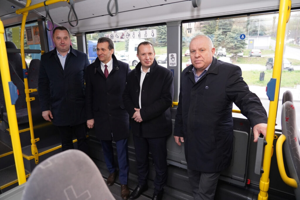 Czterech mężczyzn stoi w autobusie.
